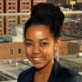 Maya James in a black shirt standing in front of a building