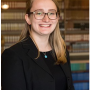 Annee, wearing all black, smiling in Riggs Library