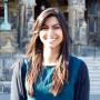 Ashianna Jetha, wearing blue and black, standing in front of Healy Hall