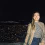 Hannah Byrne standing in front of a night skyline view of Bogota, Colombia