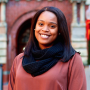 Shakera, wearing a black scarf and rust colored shirt, standing in front of Dalghren Chapel