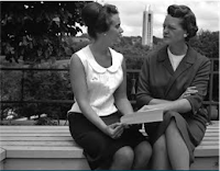 Two women talking on a bench in a park