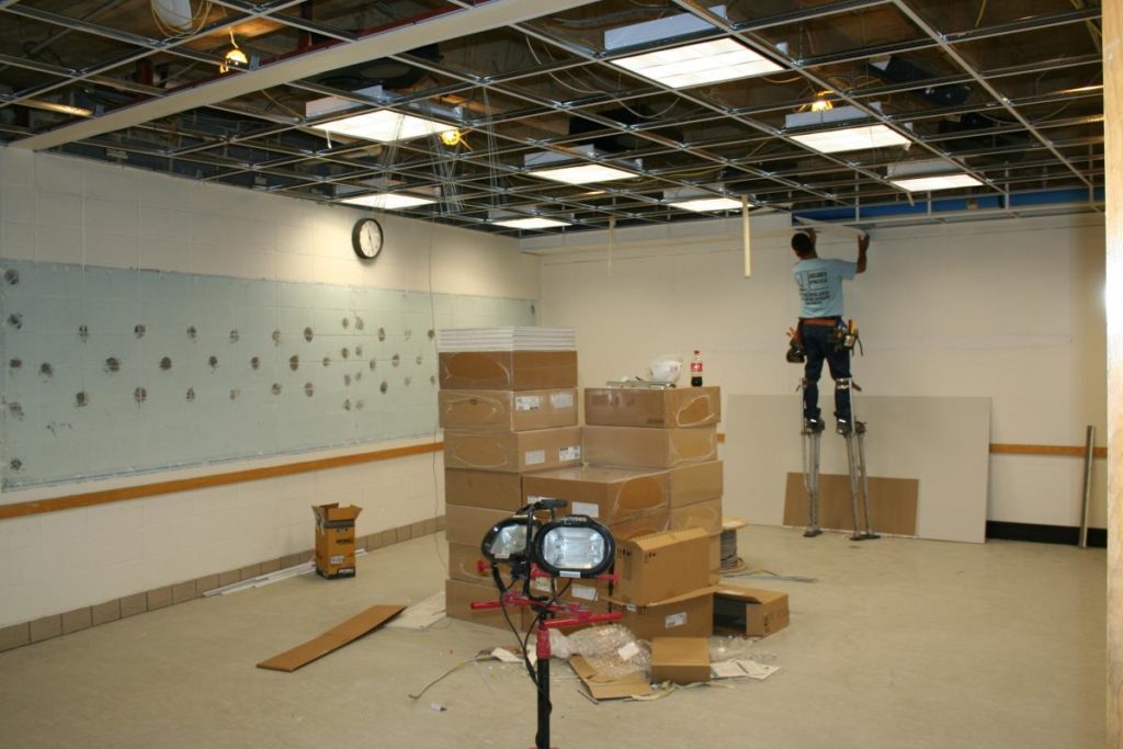 A contractor installs new ceiling grids
