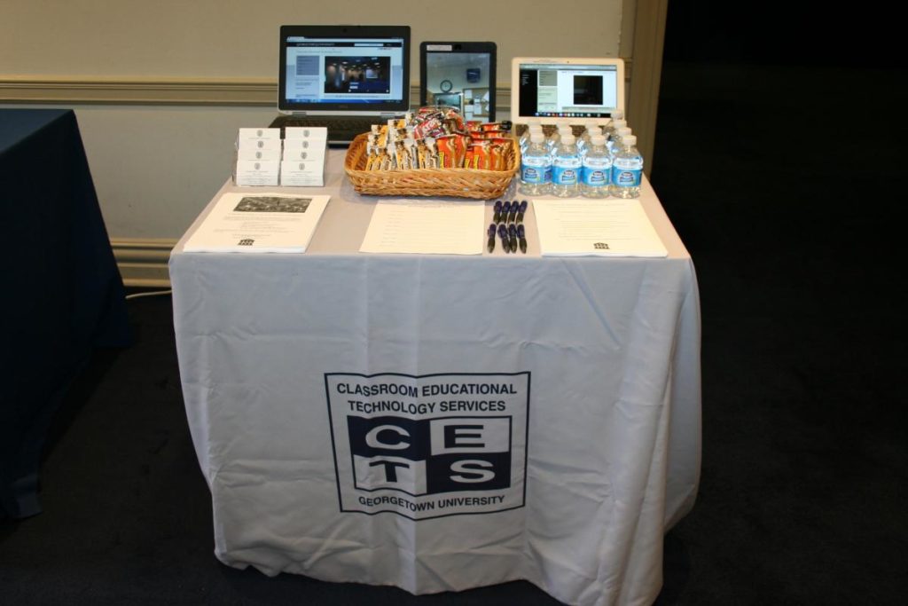 The CETS table at New Faculty Orientation in 2016. It is covered with forms, presentations, and free goodies.