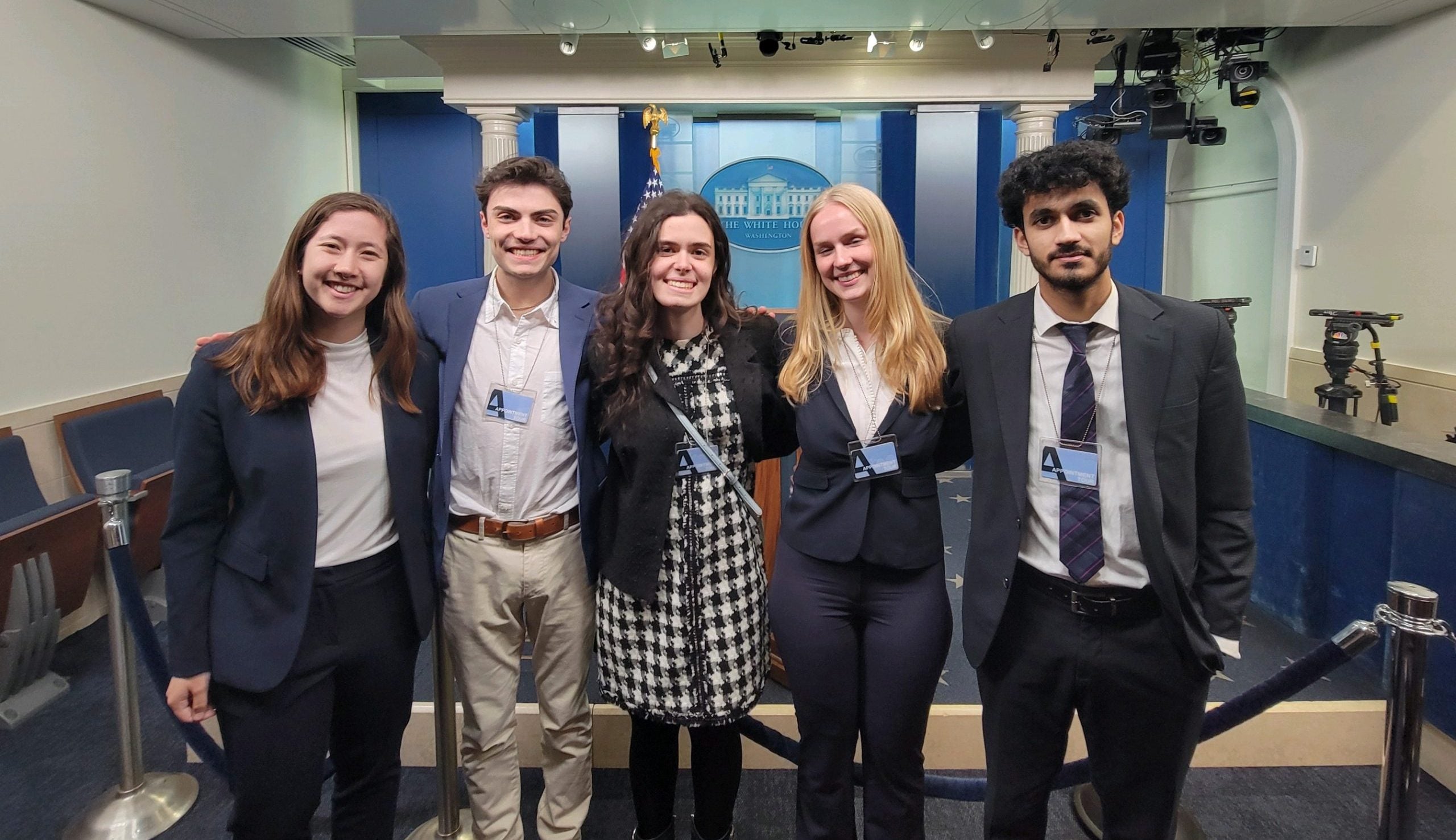 Students from Fellow Marc Short's student strategy team smile for photo in front of White House press briefing room.