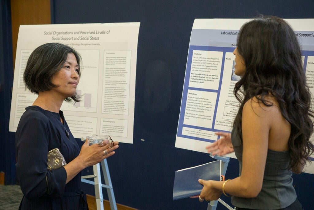 Senior Maya Chatham discusses their presentation with Professor Yuki Kato