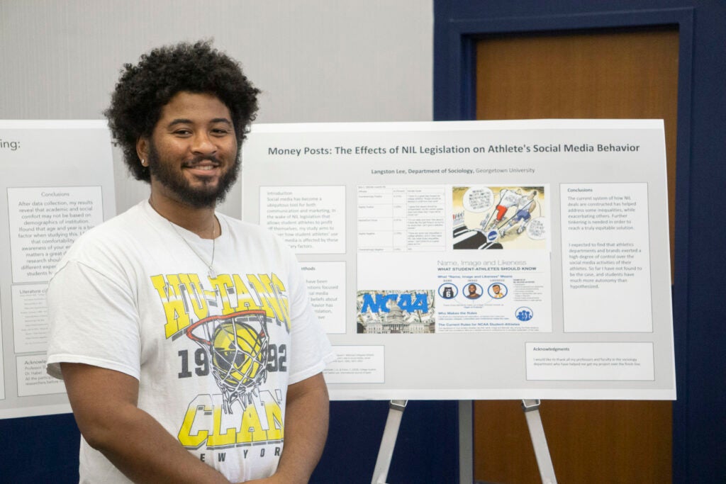 Senior Langston Lee poses in front of their presentation