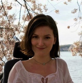 Anna Landre in front of Tidal Basin in with Cherry Blossoms in bloom